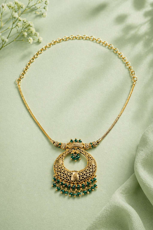 Ornate gold necklace with green gemstones