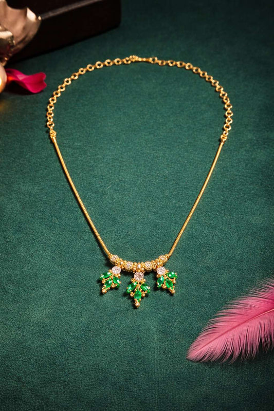 gold necklace with emerald pendant and ad
