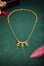 gold necklace with emerald pendant and ad